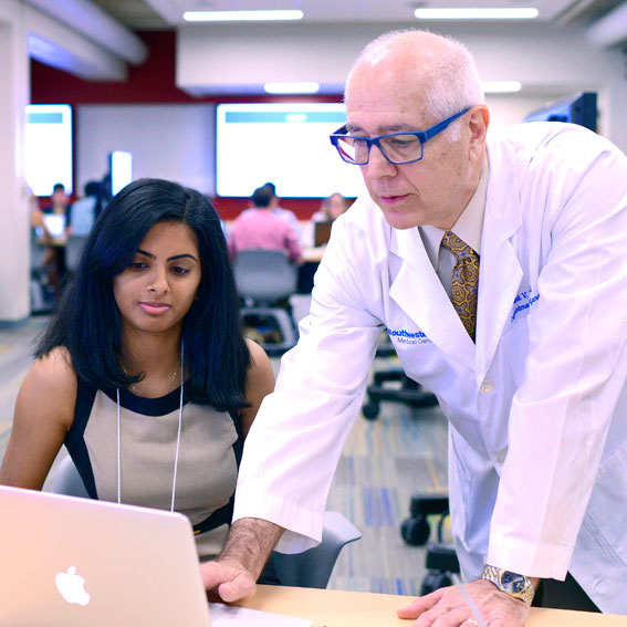 Faculty looking at laptop with female student