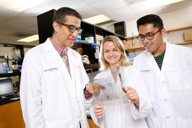 Dr. Jeffrey Zigman looks over test results with a female and a male student researchers