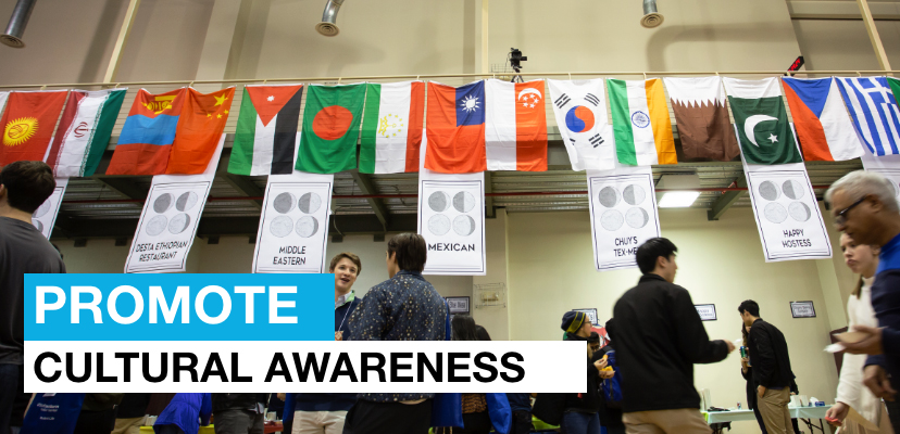 People standing in front of flags of many nations and the message: Promote Cultural Awareness