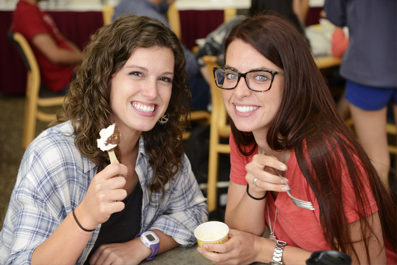 Two women eat ice cream at an ice cream social