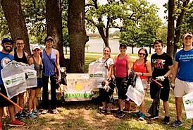 Group of people holding bags to clean up a park