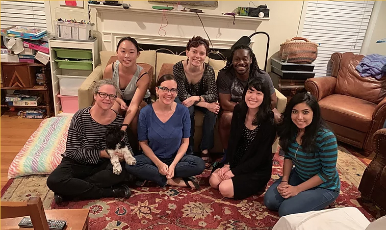 group of people seated on the floor in a living room