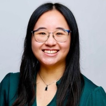 Portrait of Vivian Duong young woman with long dark hair wearing dark green shirt and glasses