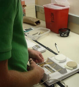 Resident tying sutures on simulation setup