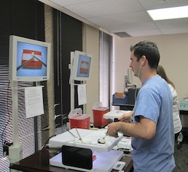 Man looking at screen while using surgical instruments