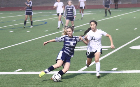 Paige dribbles the ball around a defender