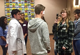Students perform an eye test using an ophthalmoscope.