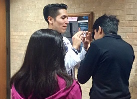Students perform an eye test using an ophthalmoscope.