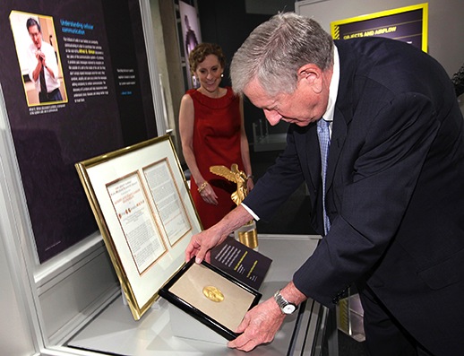 Dr. Alfred G. Gilman places his donated 1994 Nobel Prize Medal for display at the Perot Museum