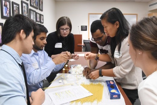 Students working on a spaghetti-and-marshmallow tower during Convergence Days.