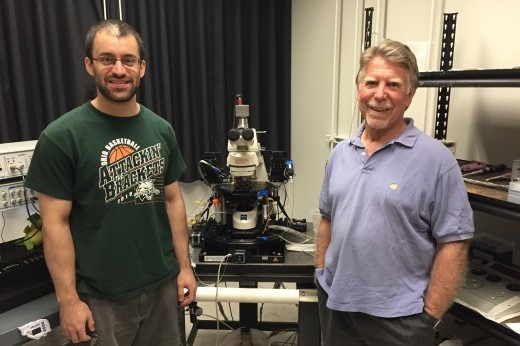 Dr. Robert Greene (right), Professor of Psychiatry and Neurosciences at UT Southwestern Medical Center, and Alex Sonneborn, in the UTSW neuroscience graduate program, stand next to a Zeiss Axoskop2.
