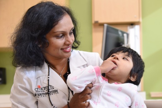 Dr. Sailaja Golla greets 3-year-old Naomi, a Rett patient at UT Southwestern.