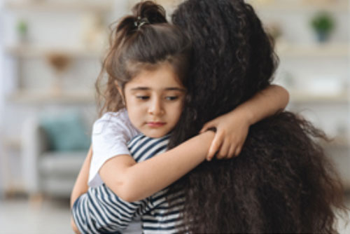 sad little girl being carried away by woman