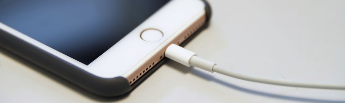 partial photo of iphone with charging cable connected