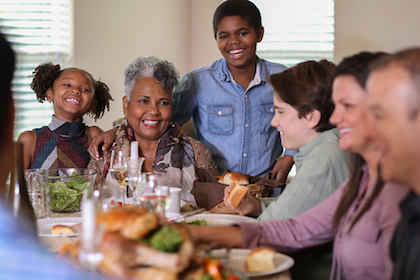 Decorative photo of ethnically diverse family enjoying meal together.