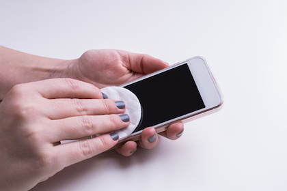 Woman cleaning mobile phone display