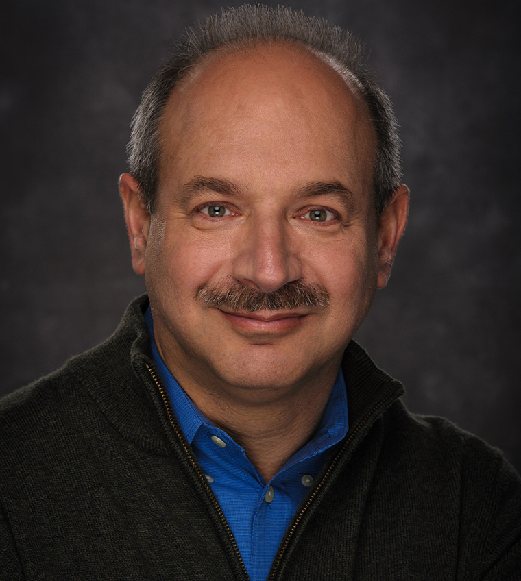 A man with glasses and a purple shirt