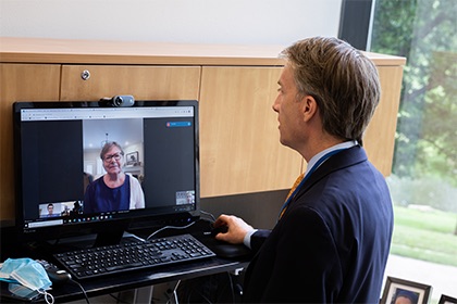 A doctor talking with a patient through a laptop