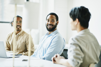 Three diverse men sitting around a table