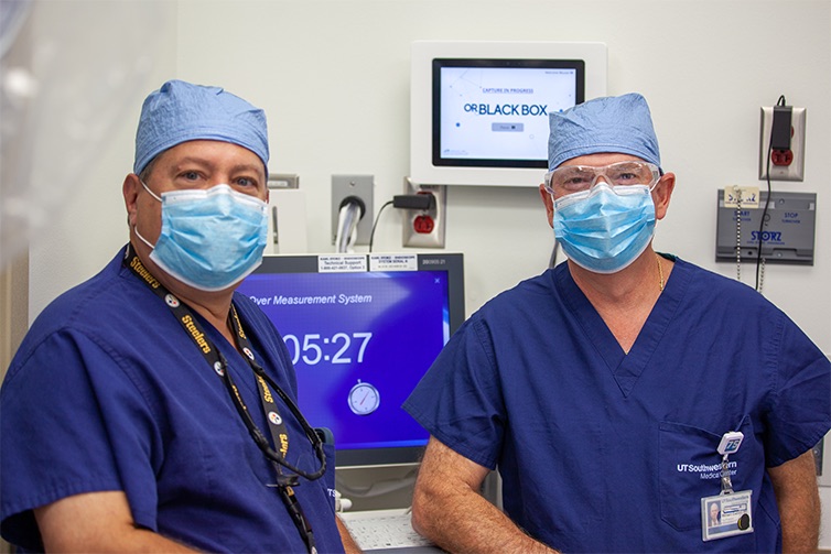 Dr. Herbert Zeh and Dr. William Daniel stand in front of the OR Black Box control screen.