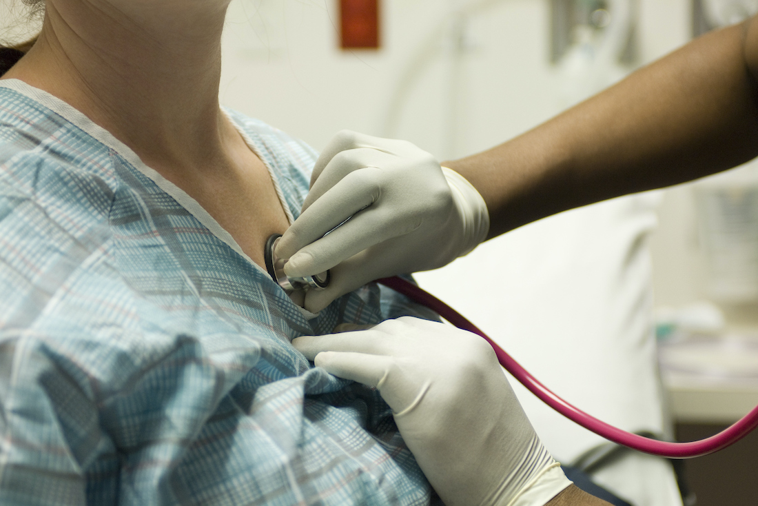 Doctor listening to patient's chest with stethoscope