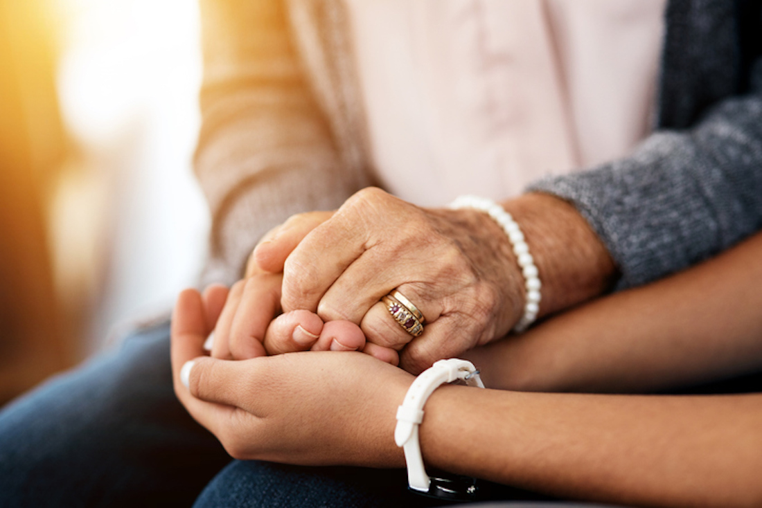 Cropped shot of a nurse holding hands with a senior woman