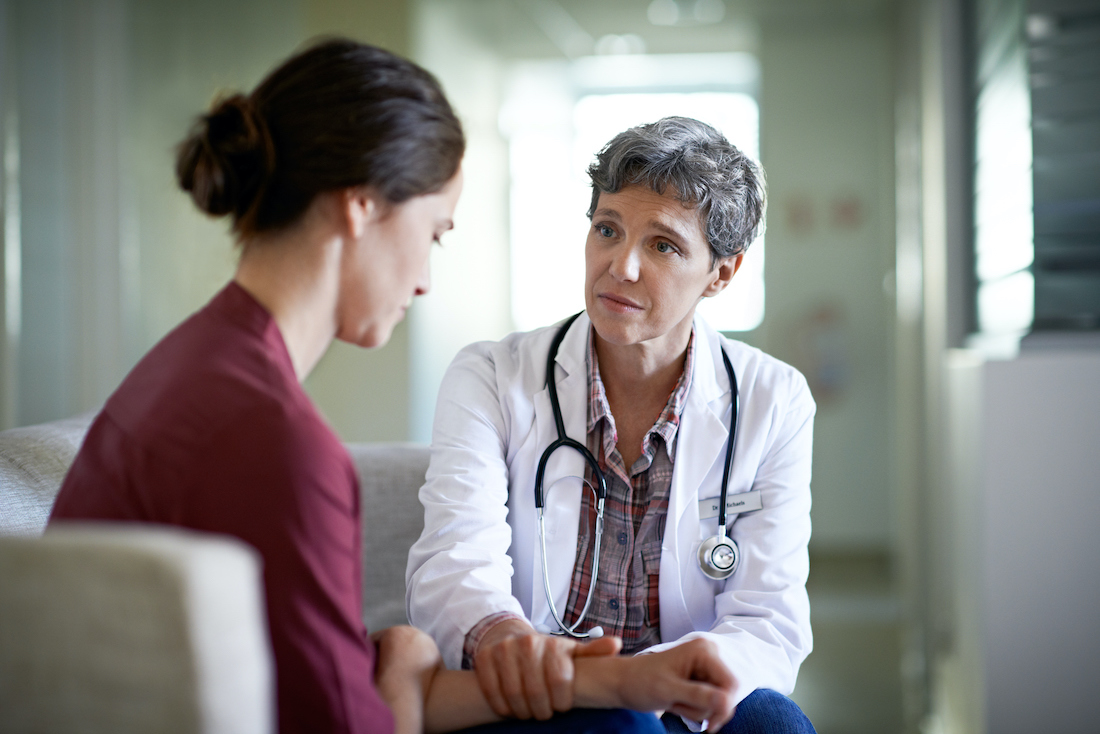 Shot of a compassionate doctor comforting a young woman in a hospital waiting room