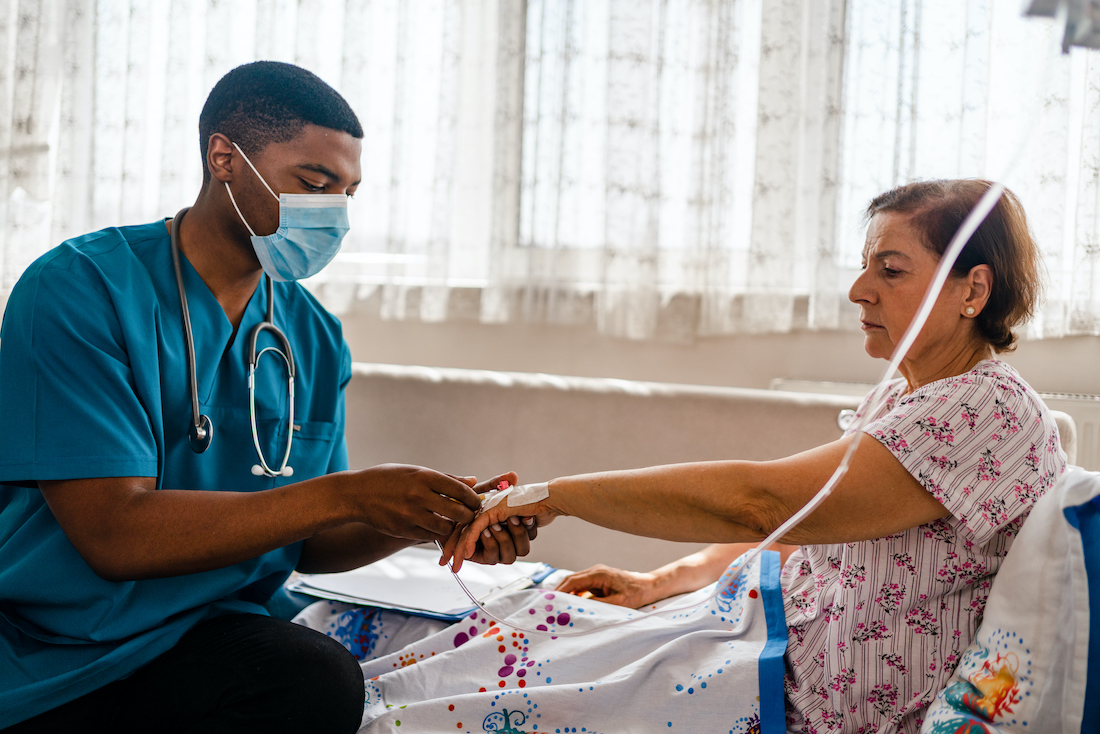 male nurse attaching IV drip on patient
