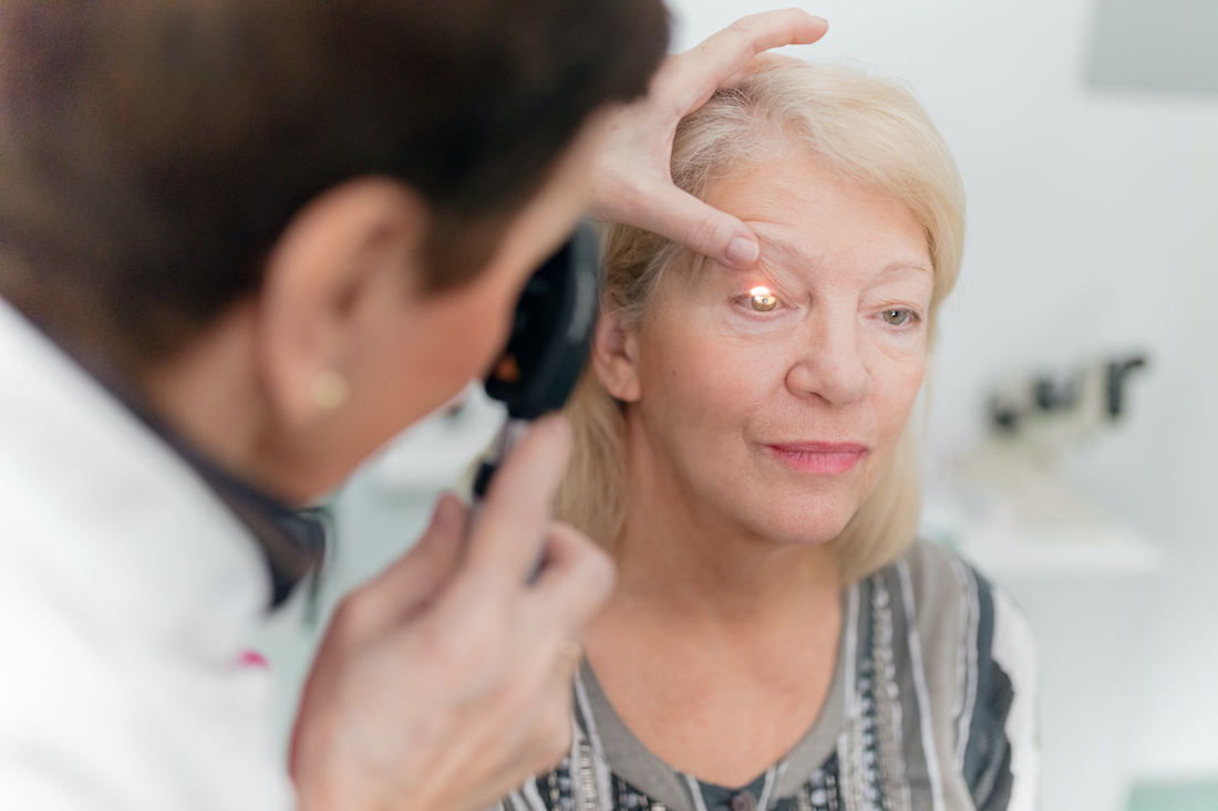 Optician looking into patients eyes