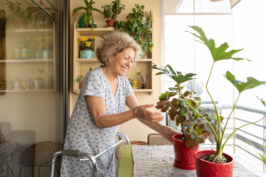 Elderly woman with a disability taking care of her plants