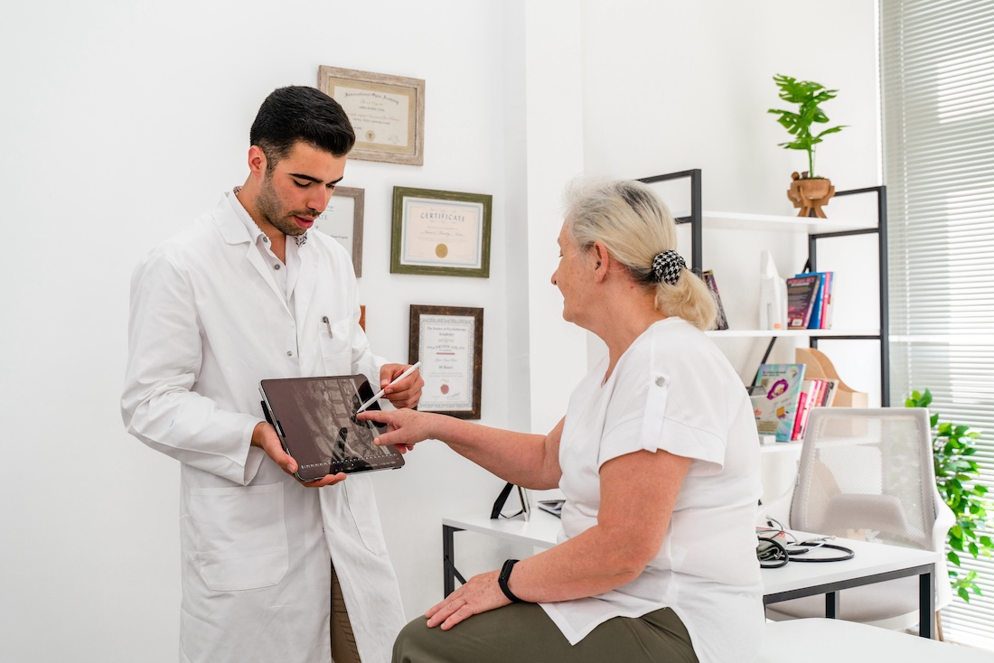 Shot of a young doctor using a digital tablet during a consultation with a senior woman