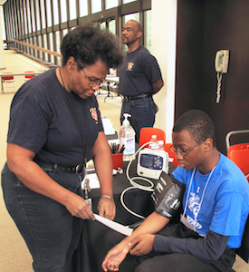 During HPREP, Allison Green (left) conducts a blood pressure exam on Samuel LaJuwomi, a high school junior.