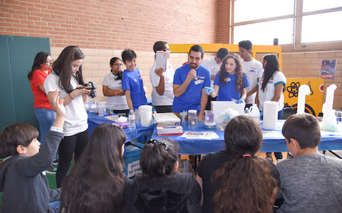 Several medical students from UT Southwestern share information with a young audience at Thomas J. Rusk Middle School.