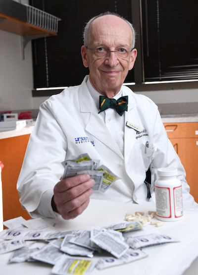 Dr. Lee holding packets of acetaminophen-containing products