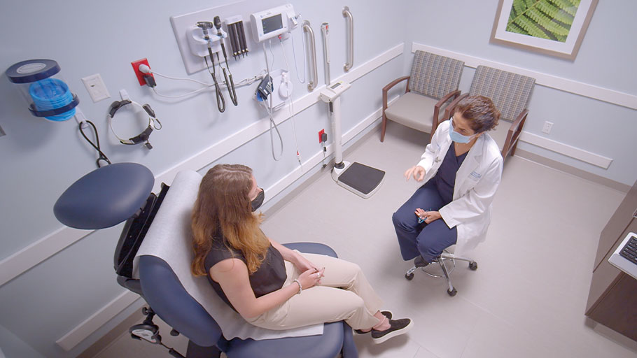 overhead photo of a female doctor and female patient talking in an examination room