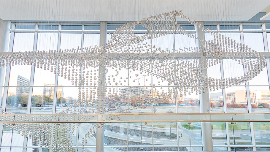 Sculpture made of stainless steel spheres suspended from the ceiling by steel cables