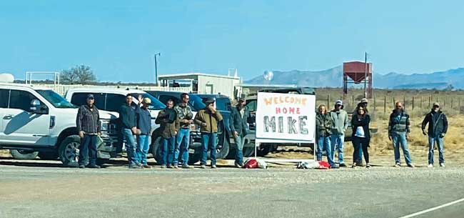 Blue Origin Ranch employees wait along the highway with a sign welcoming Michael Schulze back home from the hospital.