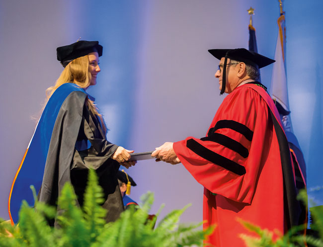 Graduate School of Biomedical Sciences student Tahnae Tarkenton Allen receives her diploma from UT Southwestern President Daniel K. Podolsky, M.D.