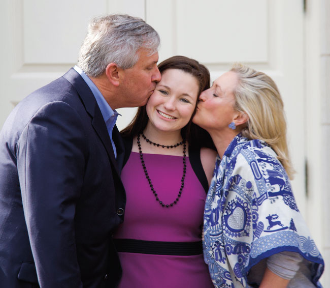 Bette Rathjen, center, with her parents leaning in to kiss her face on each side, Karl Rathjen, M.D., left, and Carolyn Perot Rathjen