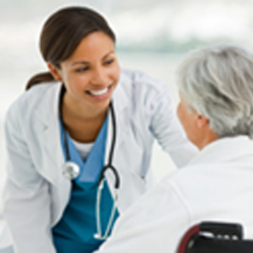 A  doctor smiling at her elderly patient