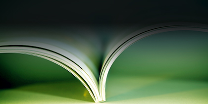 top view of open book pages, green background