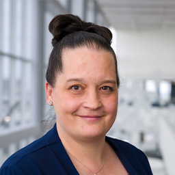 Woman with dark hair wearing blue blouse