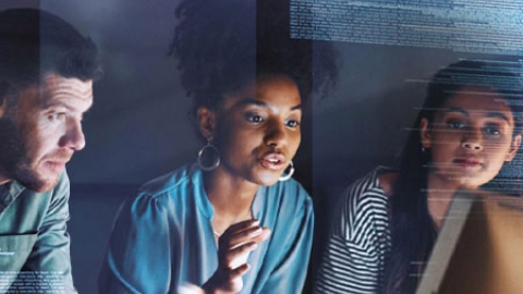 Three students having a discussion while looking at screen