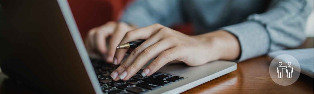 A woman types on a laptop keyboard