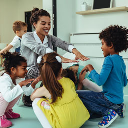 A woman plays with three young children