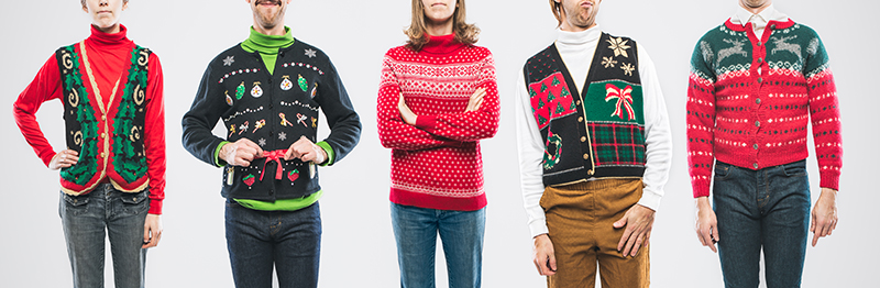 Five men and women wearing red, black, or green holiday sweaters or vests