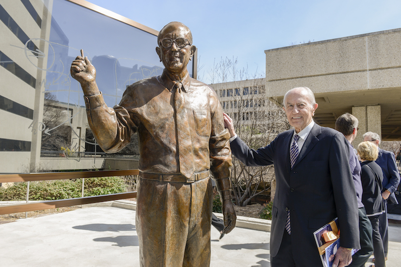 Dr. Donald Seldin Plaza posing with a 7-foot bronze statue in his likeness.