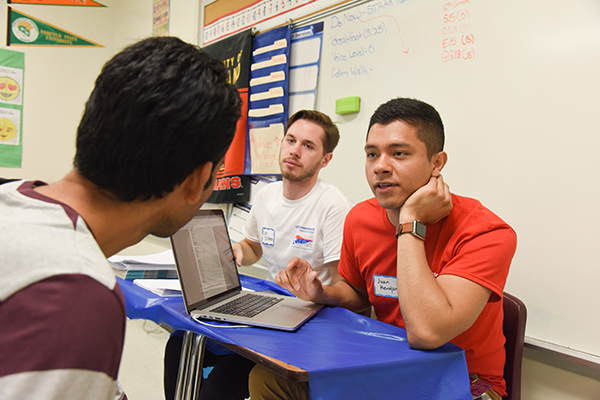 Medical students Luke Bushman and Juan Herrejon help a United to Serve attendee complete a medical history.