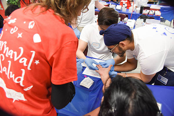 Dr. Nora Gimpel supervises medical students J.K. Gulati and Ethan Fan as they draw blood.