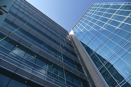 Side of West Campus Building 3 with full glass window panes and a blue sky